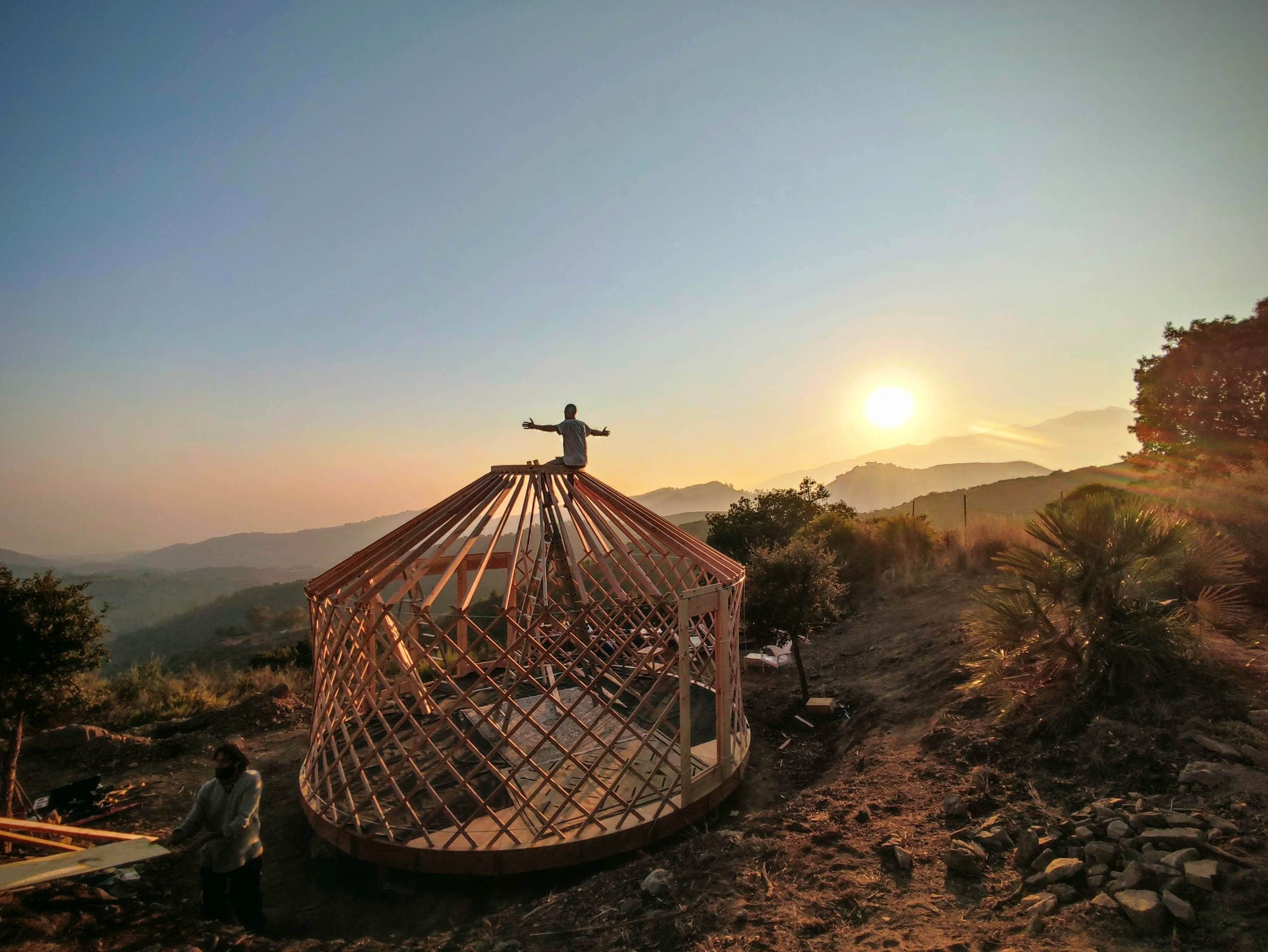 Construcción exterior de yurta al atardecer en montaña mediterránea