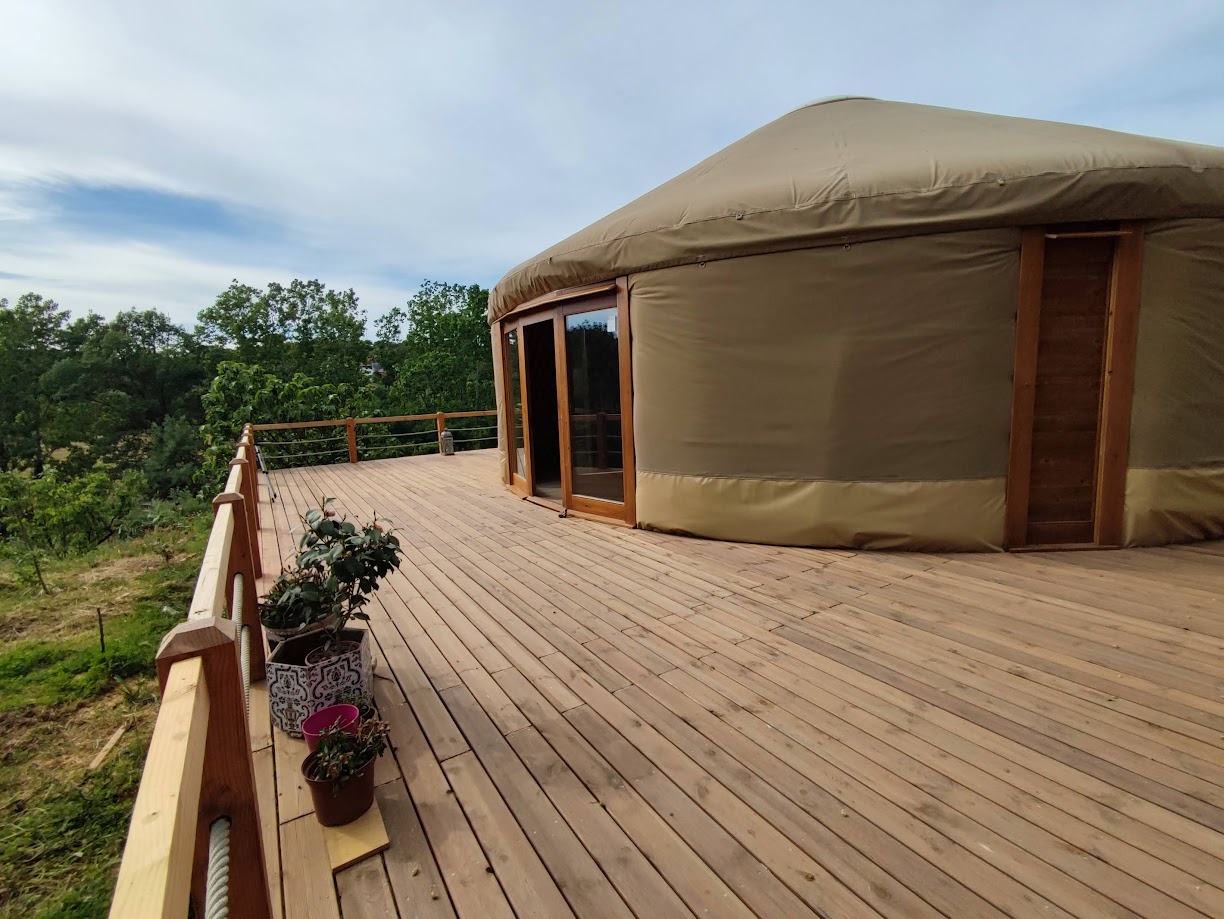 Yurta moderna terminada con terraza de madera en entorno rural